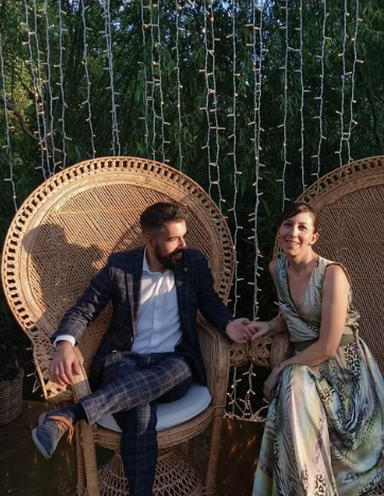 Andrea e Monia sorridono, seduti vicini su due poltrone di vimini.